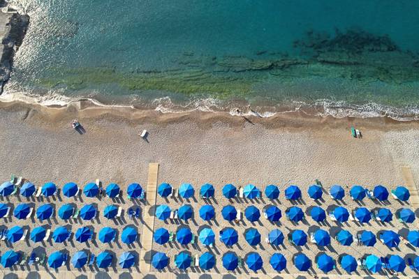 Oberflächenansicht von Strand mit blauen Sonnenschirmen und Meer