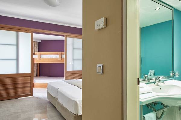 Doppelzimmer im Esperides Beach Resort mit Doppelbett und Etagenbett.