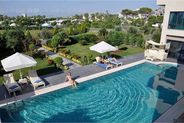 Aussenpool des Susesi Luxury Resorts mit Loungebereich und Sonnenschirmen.