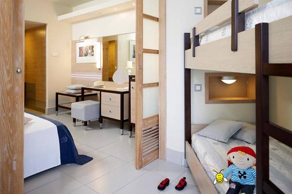 Doppelzimmer im Esperides Beach Resort mit zwei Betten, Schreibtisch und Schrank.