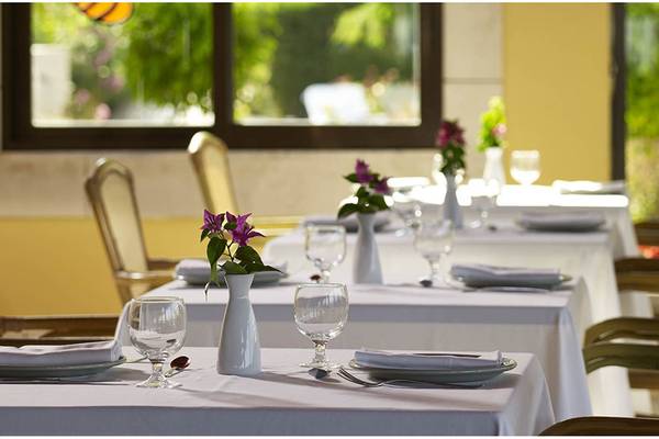 Reservierungstisch im Restaurant des Esperides Beach Resort mit Blumen und Geschirr.