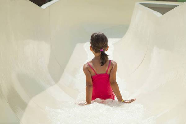 Kleines Mädchen rutscht in einer weißen Wasserrutsche des Esperides Beach Resorts