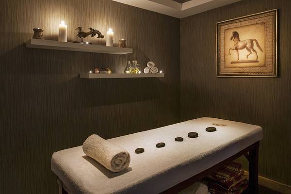 Spa-Massage-Raum im Prive Hotel Bodrum mit Massagetisch, Kerzen und Wanddekoration.