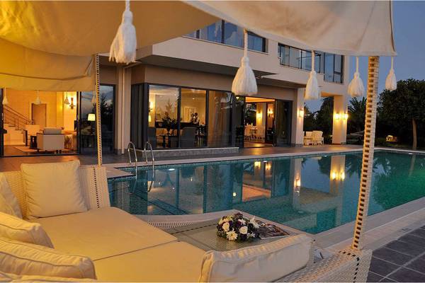 Loungebereich am Pool des Susesi Luxury Resorts mit weißen Möbeln und einem großen Schirm.