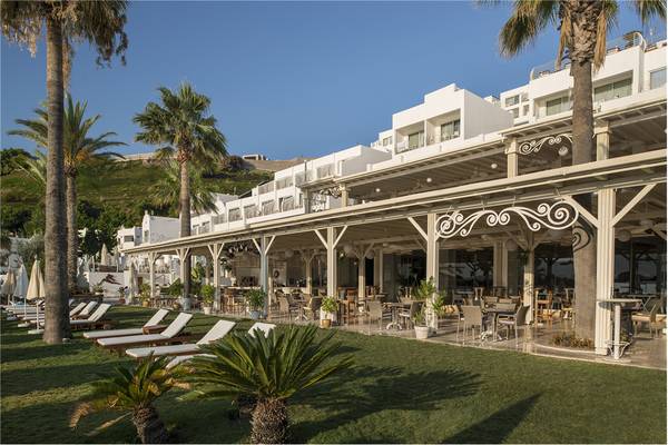 Außenbereich des Privé Hotel Bodrum mit Terrasse, Liegestühlen und Palmen.