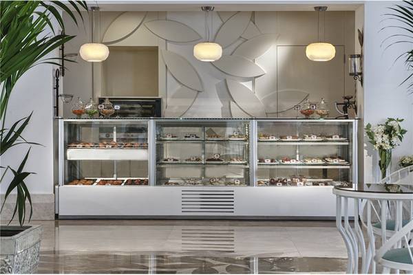Das Innere des Prive Hotel Bodrum zeigt eine Patisserie-Vitrine mit Gebäck in einer eleganten Lobby.