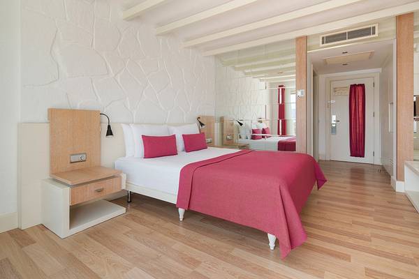 Prive Hotel Bodrum Schlafzimmer mit Bett, Nachttisch und Spiegel im Hintergrund.