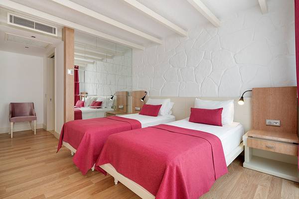 Zwei Betten mit roten Decken in einem luxuriösen Hotelzimmer von Prive Hotel Bodrum.