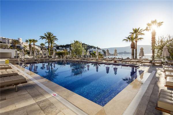 Prive Hotel Bodrum Poolbereich mit Sonnenliegen und Palmen am Meer