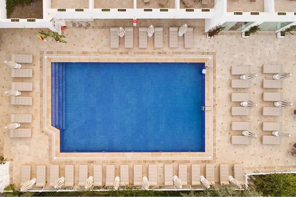 Oberflächenansicht des Pools im Prive Hotel Bodrum mit umliegenden Liegen und Pflanzen.