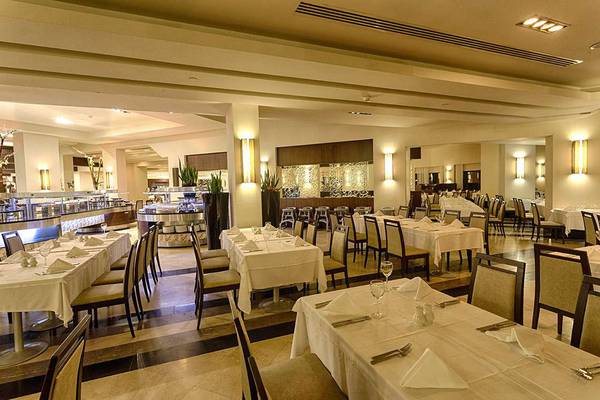 Innenansicht des Restaurants im Susesi Luxury Resort mit gedeckten Tischen und Stühlen.