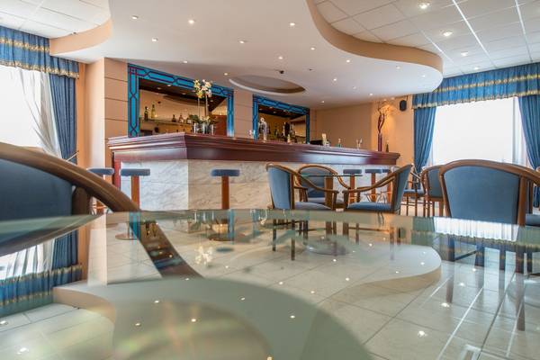 Barbereich im Astir Palace Hotel mit Tisch und Stühlen.