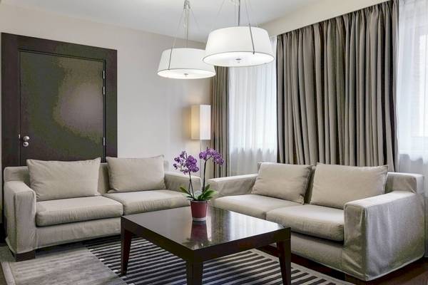 Wohnzimmer im NH Amsterdam Centre Hotel mit zwei Sofas, einem Tisch und dekorativen Elementen.