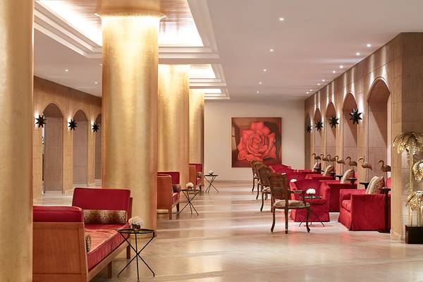 Lobby des Grecotel Lux Me Dama Dama Hotels mit roten Möbeln und einer großen roten Rose auf der Wand.