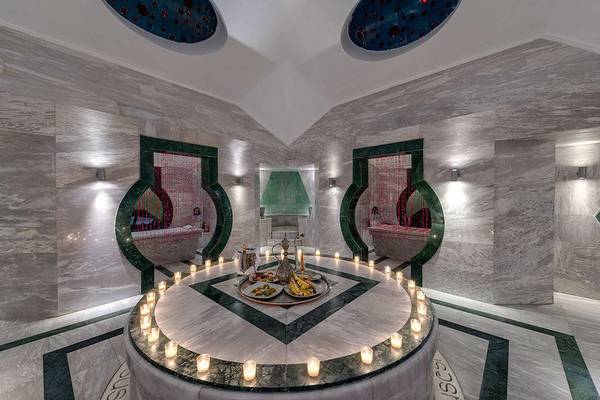 Innenansicht des Spas im Susesi Luxury Resort mit einem runden Tisch, Kerzen und Speisen.