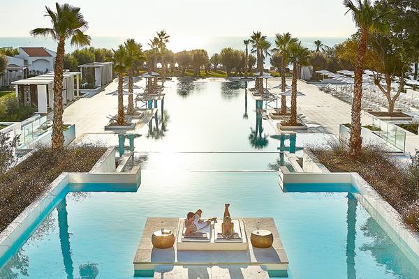Poolbereich des Grecotel Lux Me Dama Dama Hotels mit Paar, das sich entspannt.