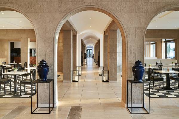 Innenansicht des Grecotel Lux Me Dama Dama Restaurants mit blauen Vasen und gemusterten Böden.