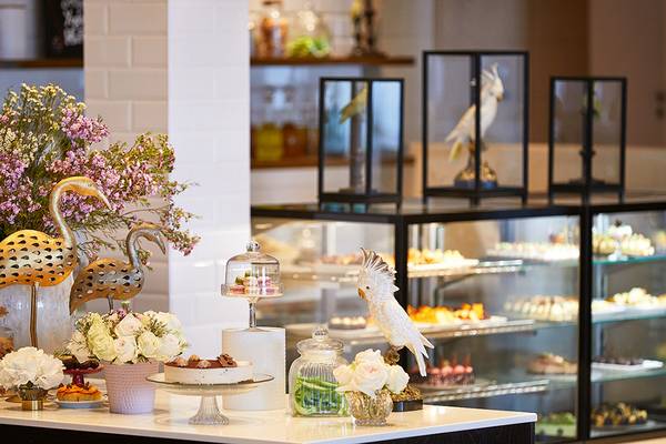 Empfangsbereich des Grecotel Lux Me Dama Dama Hotel mit Blumen, Figuren und Kuchen