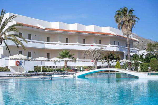 Außenpool des Niriides Beach Hotels mit Umkleidekabinen und Palmenbäumen im Vordergrund