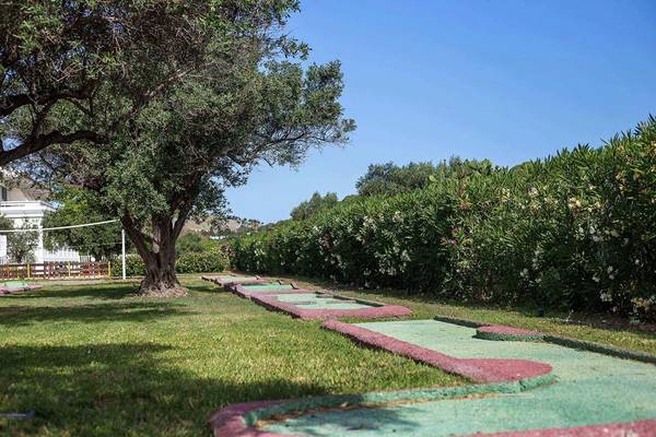 Minigolfplatz im Niriides Beach Hotel mit Bäumen und Büschen im Hintergrund.