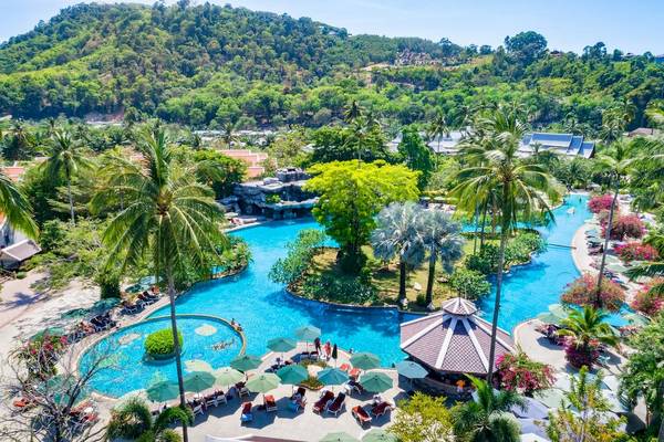 Luftaufnahme des Duangjitt Resort & Spa mit großem Pool, umgeben von Palmen und grüner Landschaft.