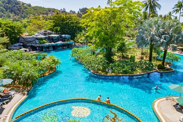 Außenansicht des großen Schwimmbeckens des Duangjitt Resort & Spa mit mehreren Gästen