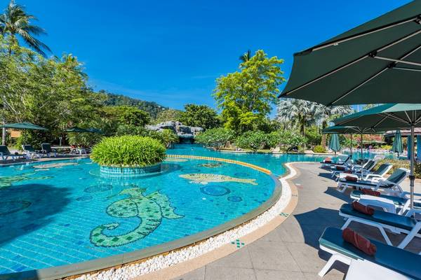 Außenpool des Duangjitt Resort & Spa mit Lounge-Stühlen und Sonnenschirmen.