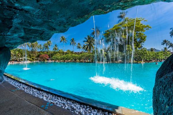 Poolansicht des Duangjitt Resort & Spa mit Wasserfall und kristallklarem Wasser.