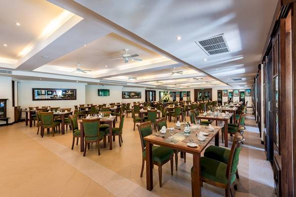 Innenansicht des Restaurants im Duangjitt Resort & Spa mit vielen gedeckten Tischen und Stühlen.