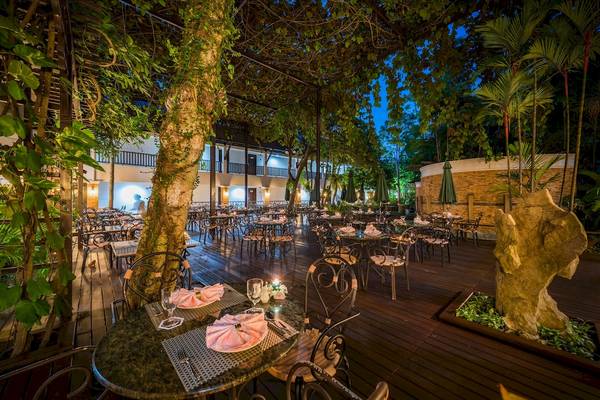 Gartenbereich des Duangjitt Resort & Spa mit Tischen, Stühlen und Pflanzen