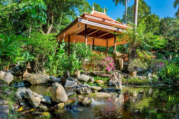 Garten des Duangjitt Resort & Spa mit einem Brunnen und einer Pagode.