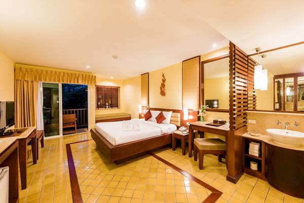 Schlafzimmer im Duangjitt Resort & Spa mit Bett, Schreibtisch und Bad