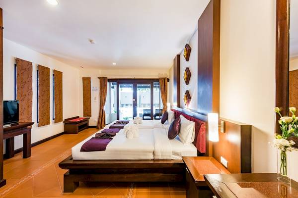 Hotelzimmer des Duangjitt Resort & Spa mit zwei Betten und einem Fernseher.