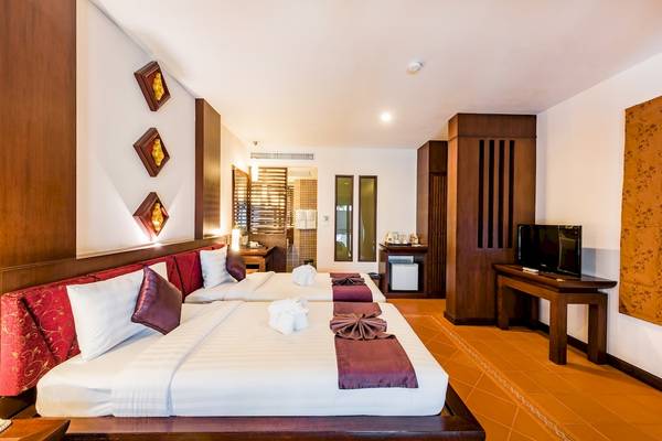 Doppelzimmer im Duangjitt Resort & Spa mit zwei Betten, Fernseher und Badezimmer