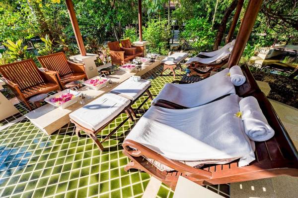 Gartenmassage-Lounge im Duangjitt Resort & Spa mit weichen Liegen und Pflanzen im Hintergrund.