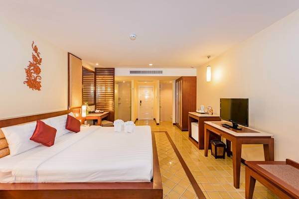 Hotelzimmer im Duangjitt Resort & Spa mit Bett, Fernseher und Dekor.