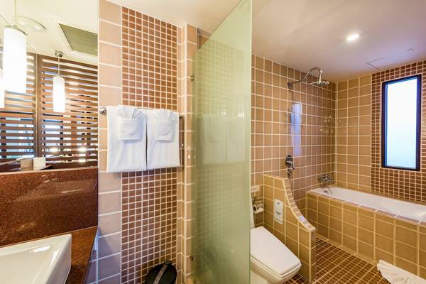 Badezimmer im Duangjitt Resort & Spa mit Badewanne, Dusche, Toilette und Handtüchern.