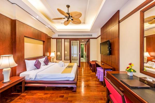 Hotelzimmer im Duangjitt Resort & Spa mit Bett, Fernseher und Schreibtisch.