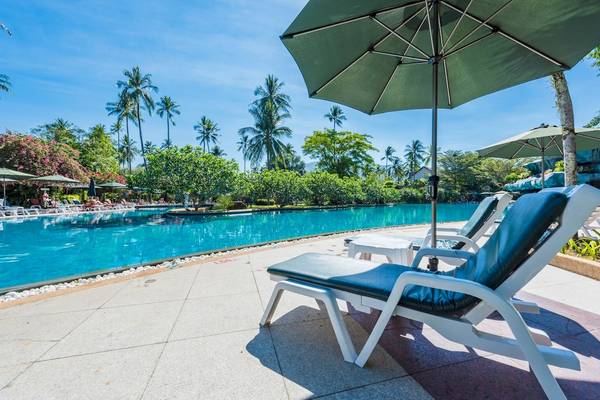 Pool-Lounge-Sessel im Duangjitt Resort & Spa mit grünem Sonnenschirm.