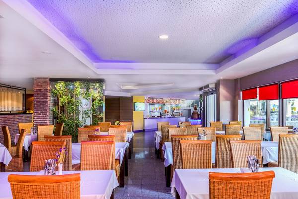 Innenansicht des Restaurants im Asteria Family Resort Belek mit gedeckten Tischen und Stühlen.