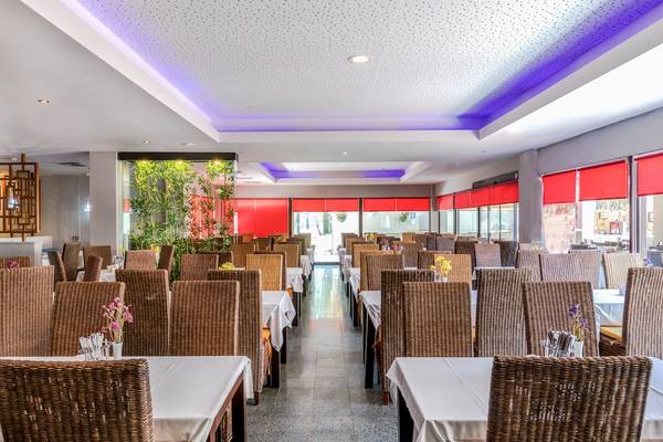 Innenansicht des Restaurants im Asteria Family Resort Belek mit gedeckten Tischen und Stühlen.