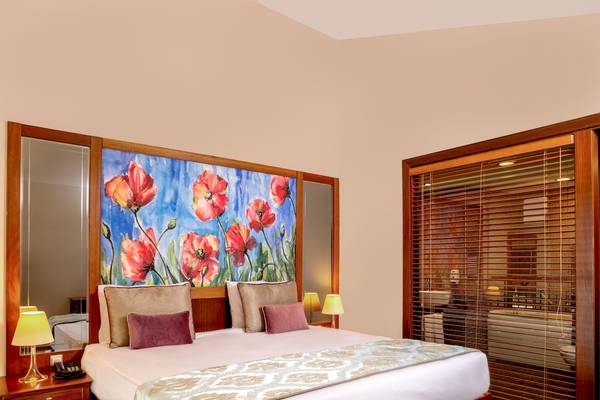 Hotelzimmer mit Blumenmalerei an der Wand und großem Bett