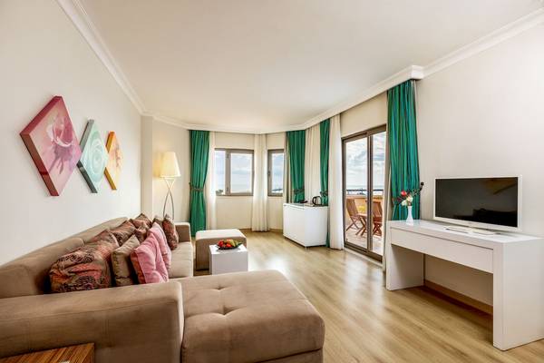 Suite im Asteria Family Resort Belek mit Wohnzimmer, Fernseher, Couch, Tisch und Fenstern
