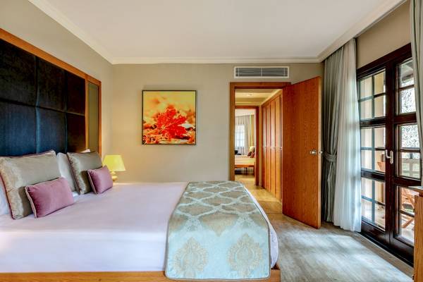 Schlafzimmer im Asteria Family Resort Belek Hotel mit Kingsize-Bett und offenem Fenster.