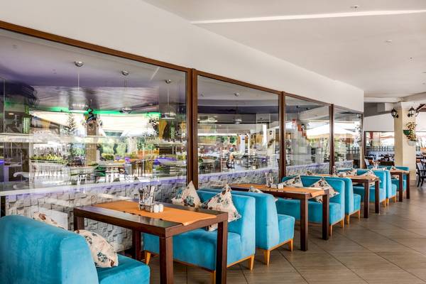 Innenansicht des Restaurants im Asteria Family Resort Belek mit blauen Stühlen und Tischen.