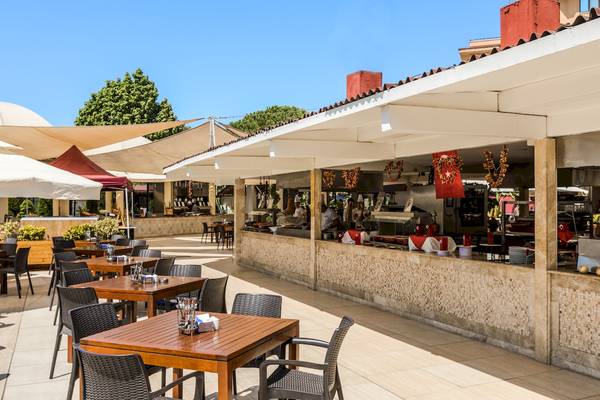 Außenbereich des Asteria Family Resort Belek Restaurants mit Tischen und Stühlen unter einem Pavillon.