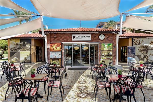Außenbereich des Coffee House im Asteria Family Resort Belek mit Tischen und Stühlen unter einem weißen Sonnensegel.