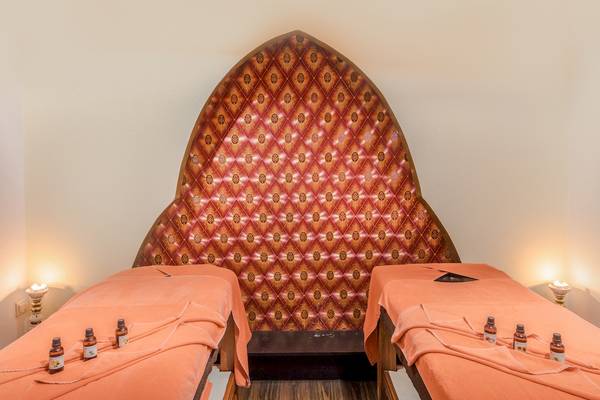Behandlungsraum im Asteria Family Resort Belek mit zwei orangefarbenen Betten und einer aufwendigen Wand.