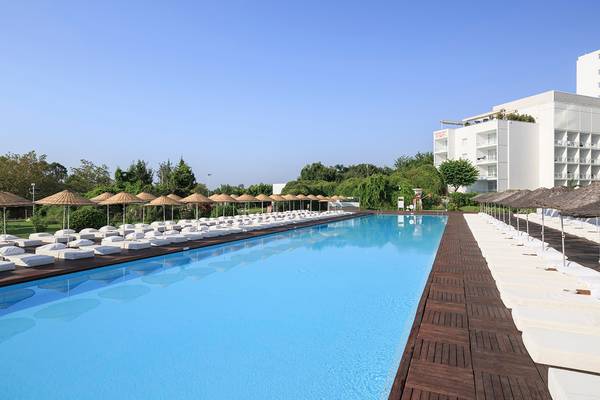 Außenbereich des Su Hotels mit großem Pool und vielen Liegen unter Sonnenschirmen