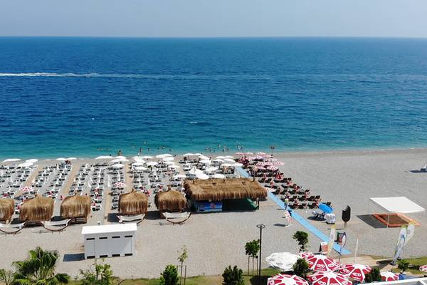 Luftaufnahme des Strandes vom Su Hotel mit vielen Sonnenschirmen und Liegen